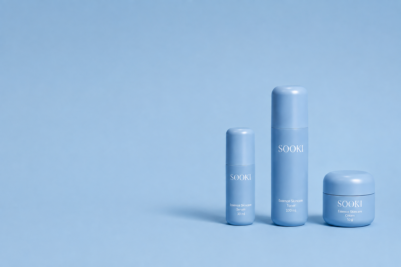 Sooki essence skincare serum, toner and cream on a soft blue background