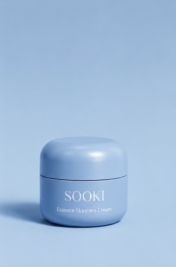 Frosted pale blue Sooki moisturizer jar on a travertine slab beside a ceramic vase